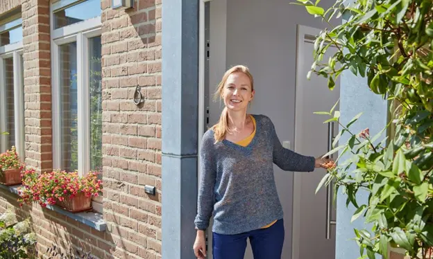 Une femme ouvre la porte d'une maison découverte