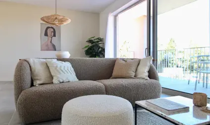 Geel Laar mooi interieur modern cementvloer living sofa zetel poef houten eettafel warme kleuren kunst schilderij