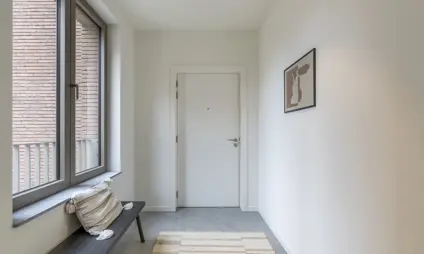 ruime inkomhal met veel lichtinval en gebruiksvriendelijke tegelvloer - afgewerkt appartement