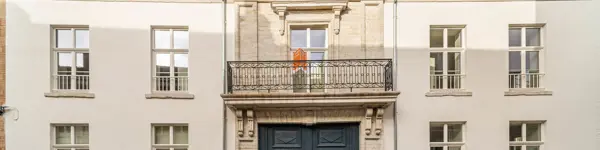 gerenoveerd statig gebouw met witte voorgevel en balkon het centrum van Tienen